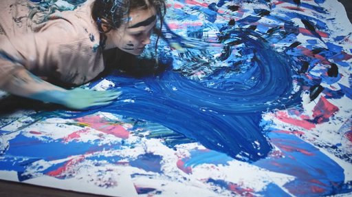 A photo of a person painting using their entire body